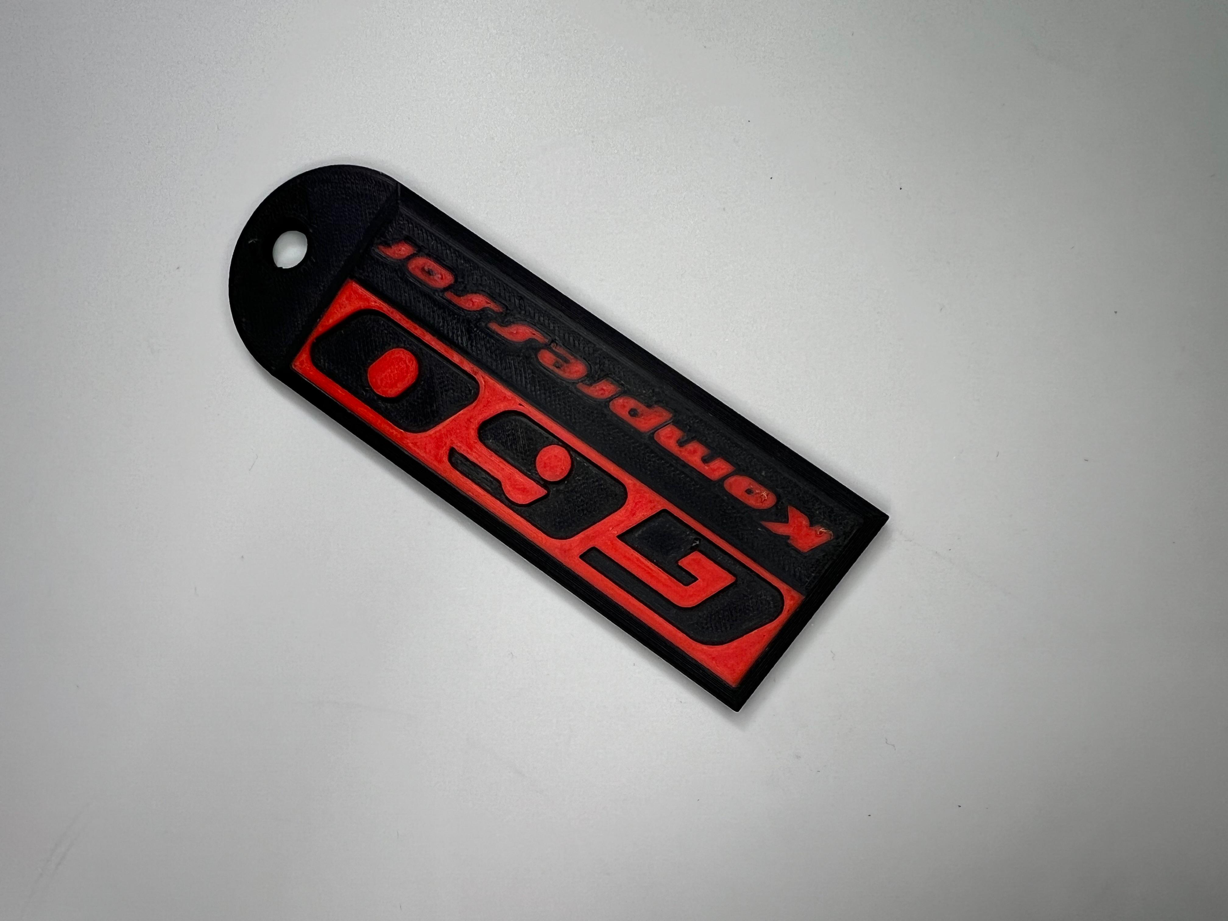 Emblem G60 Kompressor in der Farbe Rot und Schwarz aus Kunststoff