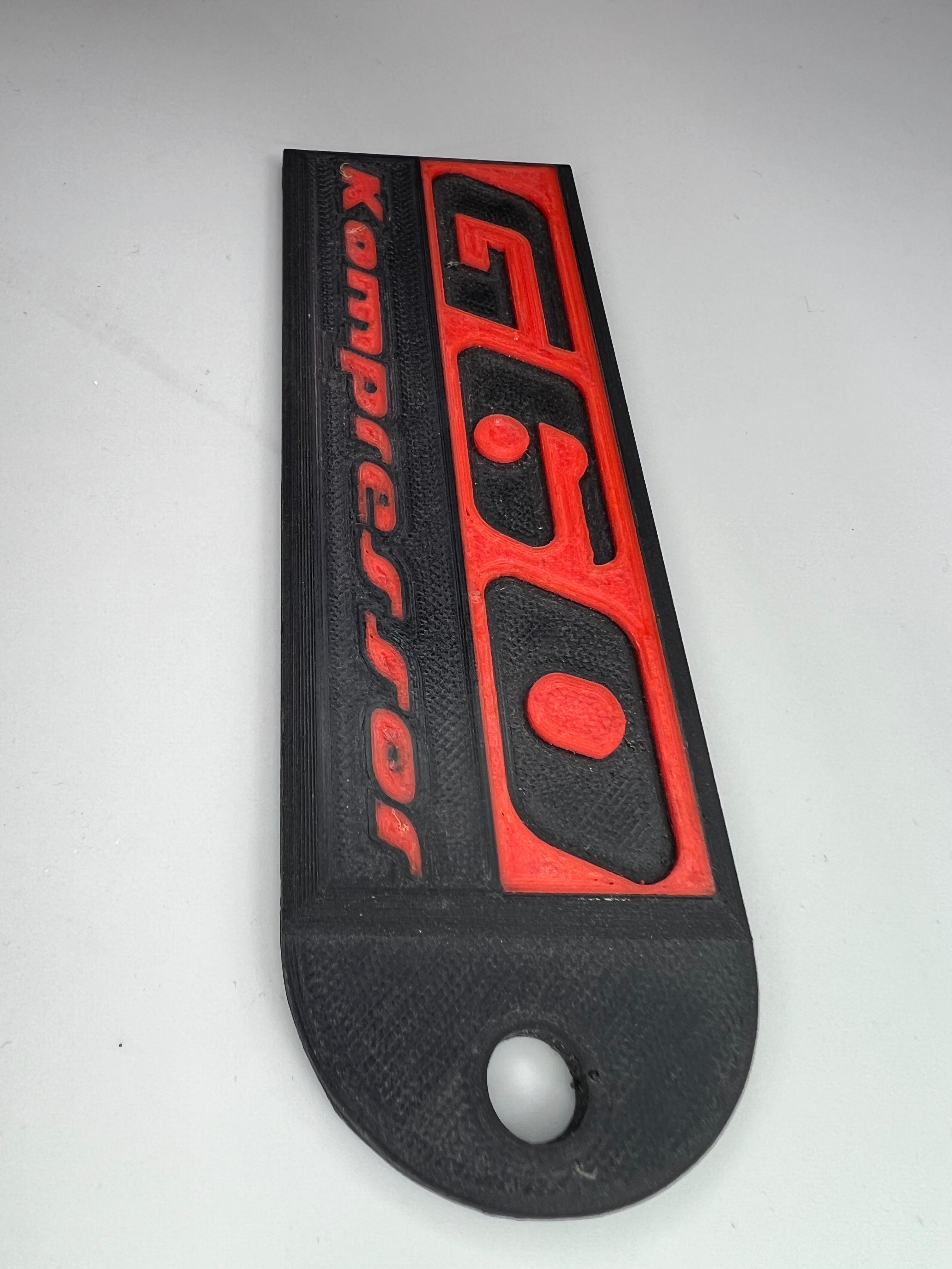 Emblem G60 Kompressor in der Farbe Rot und Schwarz aus Kunststoff