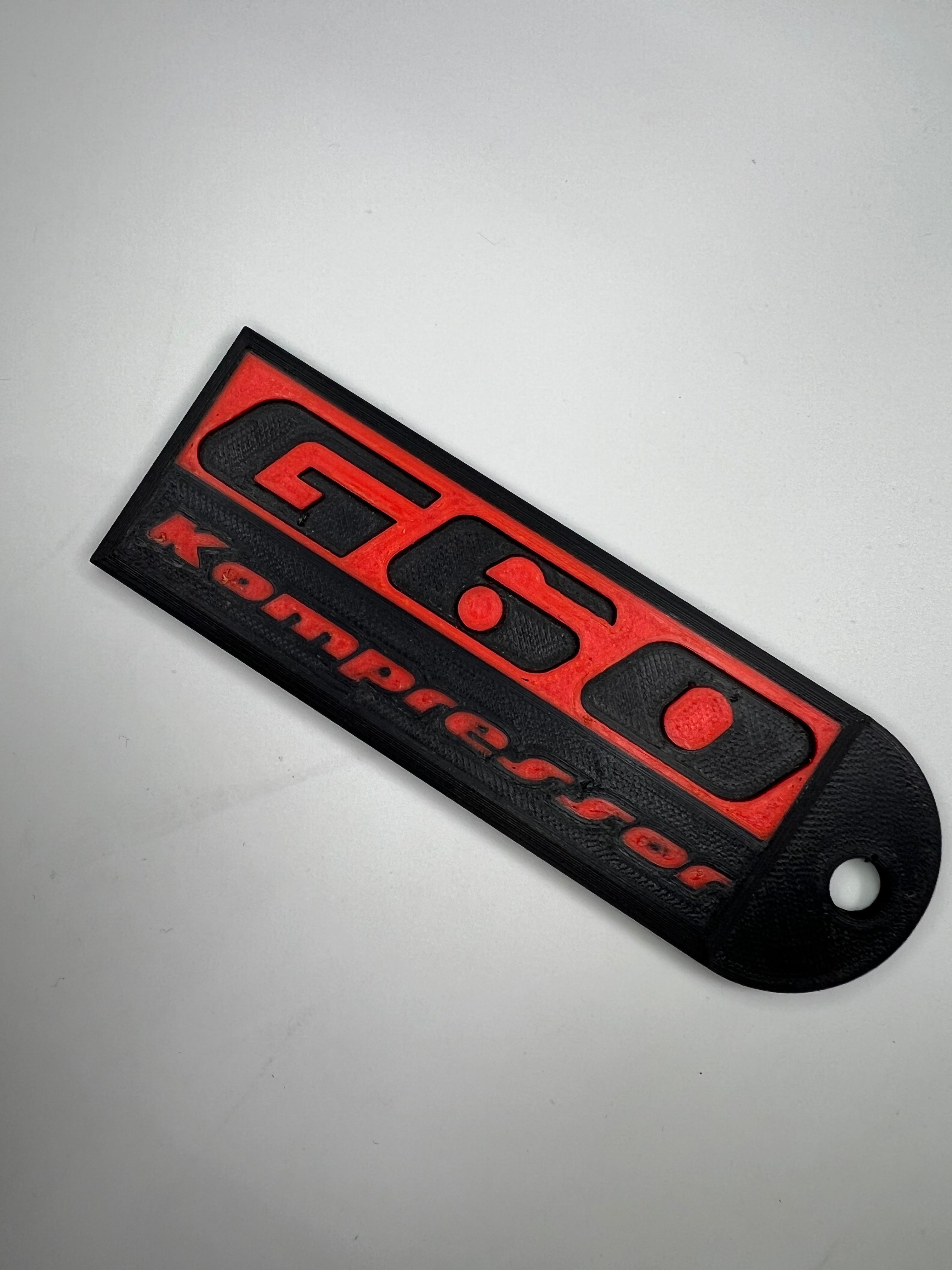 Emblem G60 Kompressor in der Farbe Rot und Schwarz aus Kunststoff
