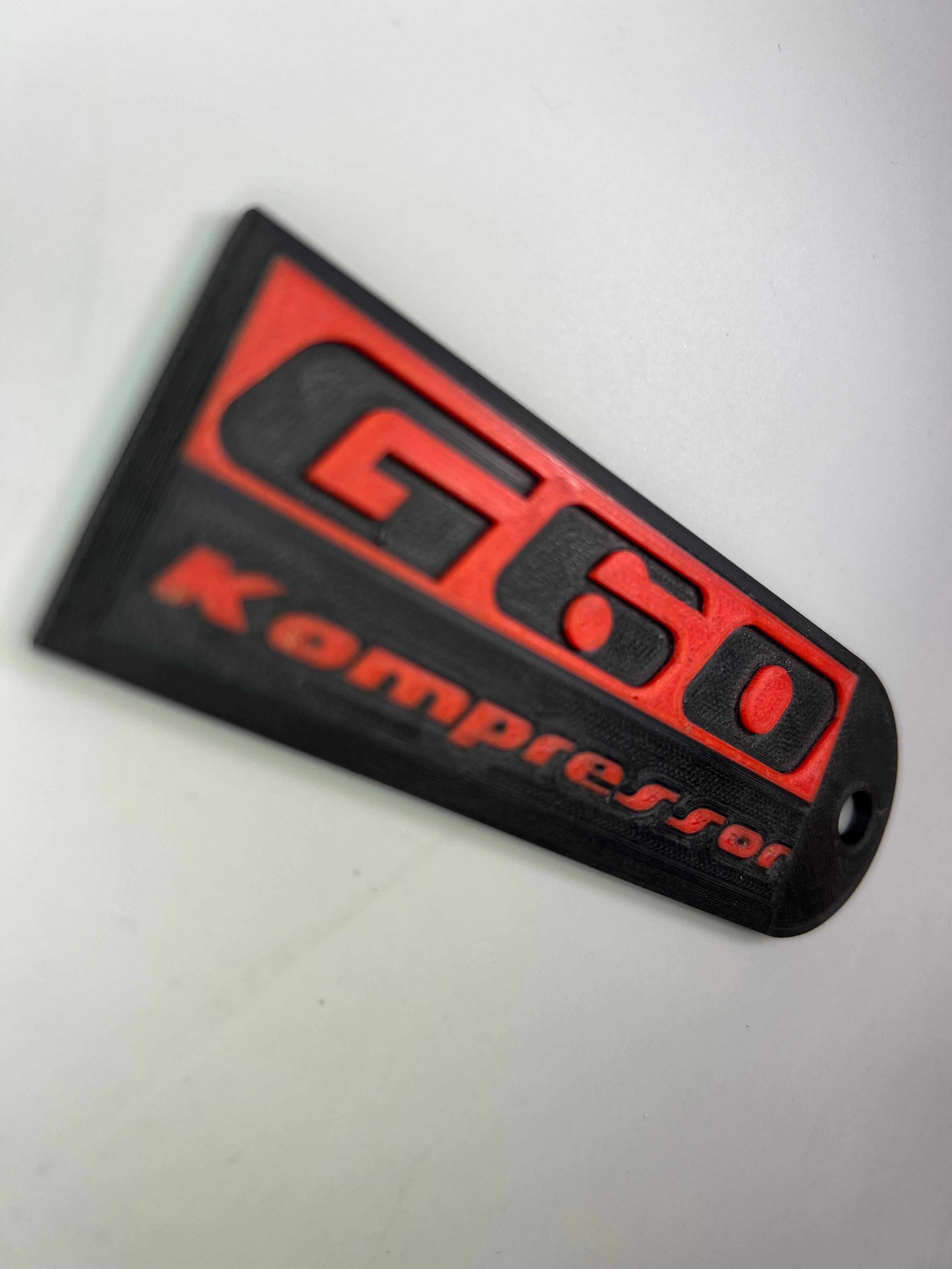 Emblem G60 Kompressor in der Farbe Rot und Schwarz aus Kunststoff