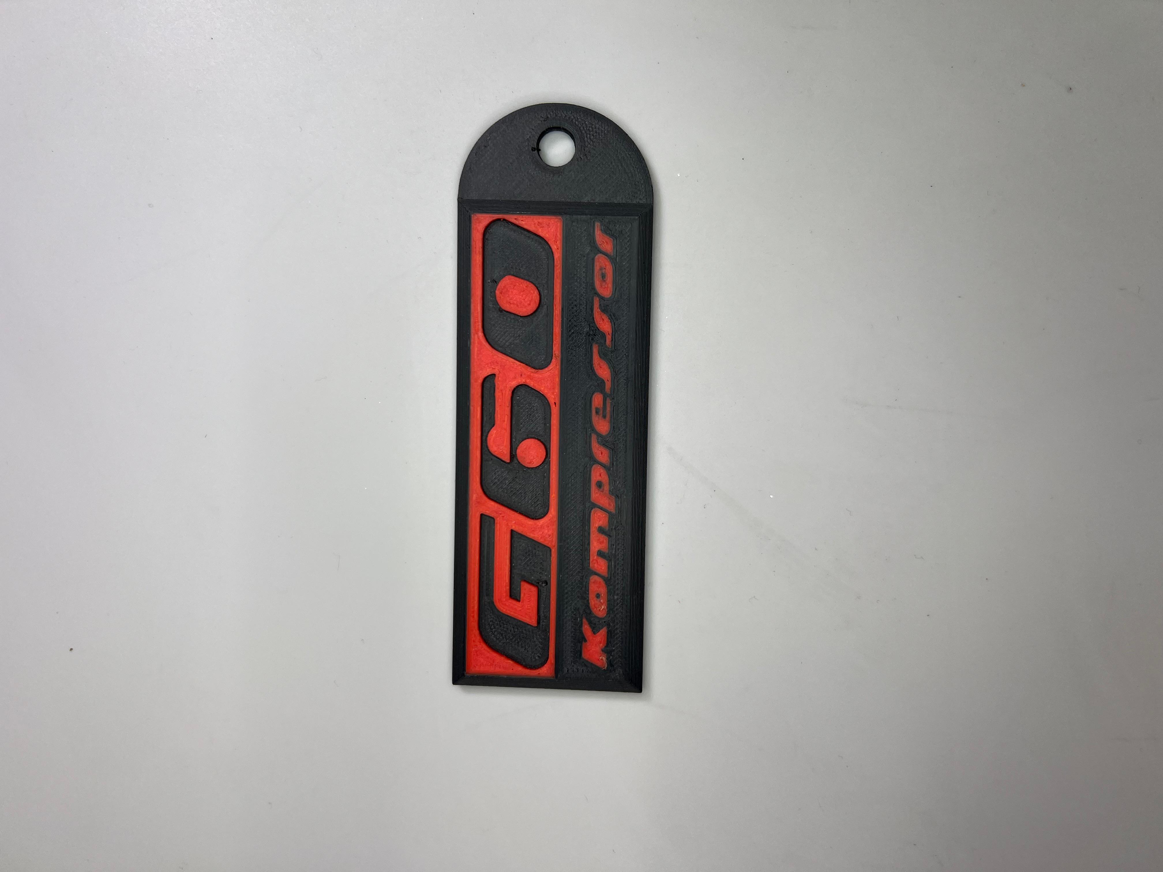 Emblem G60 Kompressor in der Farbe Rot und Schwarz aus Kunststoff