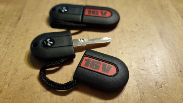 Schlüssel, roher Hauptschlüssel für Zündschloss in Kunstoffmantel mit 16V Schriftzug und Logo